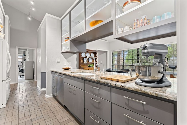 3806 Eagle Way, Round Rock, TX 78681 - kitchen with gray cabinetry, stainless steel dishwasher, brick patterned floors, freestanding refrigerator, and baseboards