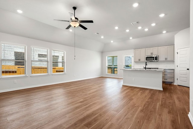341 Fawn River Run, Kyle, TX 78640 - unfurnished living room featuring lofted ceiling, ceiling fan, wood finished floors, recessed lighting, and baseboards