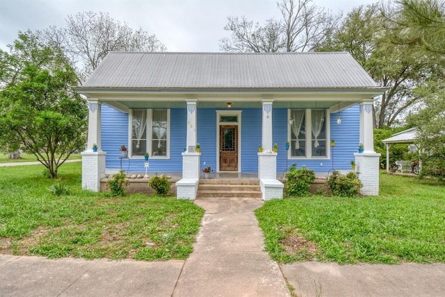 bungalow-style house with metal roof, a front lawn, and a porch