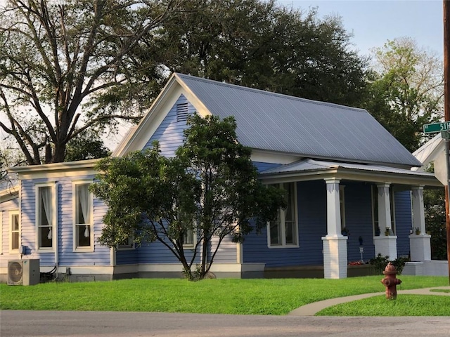 view of property exterior with metal roof, ac unit, and a yard