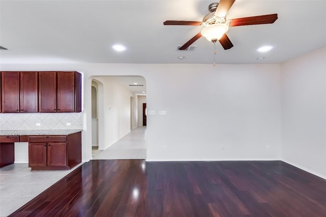 868 Water Hyacinth Loop, Leander, TX 78641 - unfurnished living room featuring arched walkways, ceiling fan, light wood-style flooring, and recessed lighting