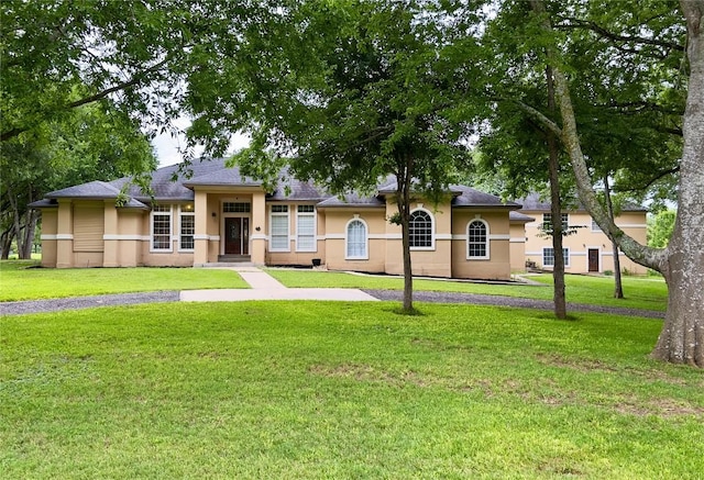 159 Moku Manu Dr, Bastrop, TX 78602 - view of front of house featuring stucco siding, a front lawn, and a shingled roof
