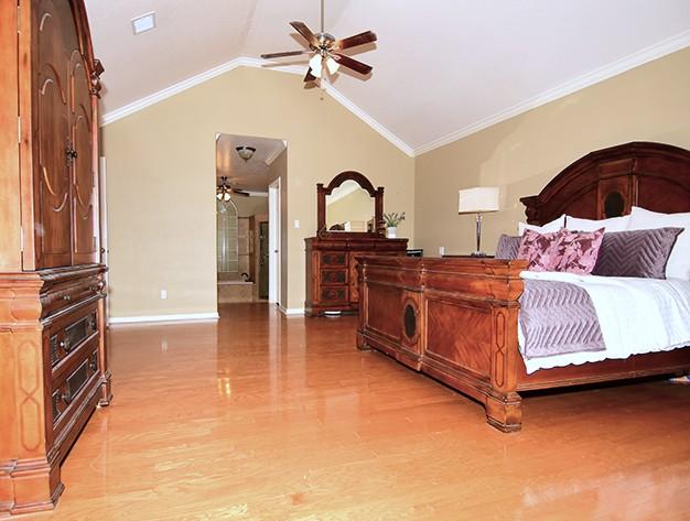 159 Moku Manu Dr, Bastrop, TX 78602 - bedroom with light wood-style floors, vaulted ceiling, crown molding, and a ceiling fan