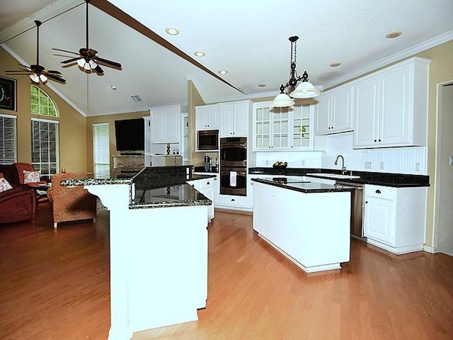 159 Moku Manu Dr, Bastrop, TX 78602 - kitchen featuring appliances with stainless steel finishes, a kitchen island, ceiling fan, wood finished floors, and ornamental molding