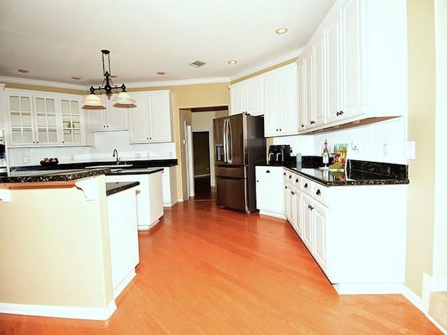 159 Moku Manu Dr, Bastrop, TX 78602 - kitchen with stainless steel fridge, light wood-style flooring, white cabinetry, hanging light fixtures, and crown molding