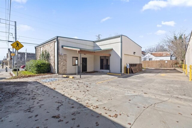 401 Main St, Blanco, TX 78606 - back of house featuring stone siding, stucco siding, and uncovered parking