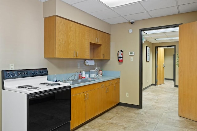 401 Main St, Blanco, TX 78606 - kitchen with white electric range oven, a sink, light countertops, and a drop ceiling