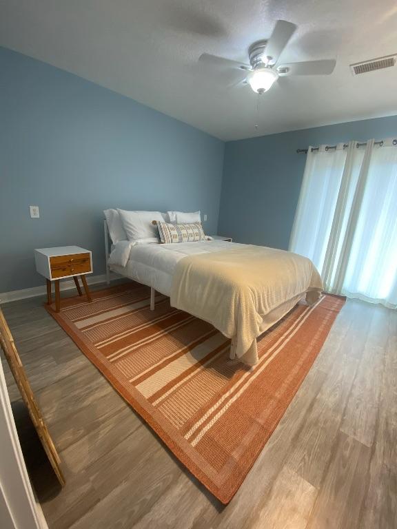 16525 Jamaica Cove Rd, Jamaica Beach, TX 77554 - bedroom featuring a ceiling fan, wood finished floors, baseboards, and visible vents