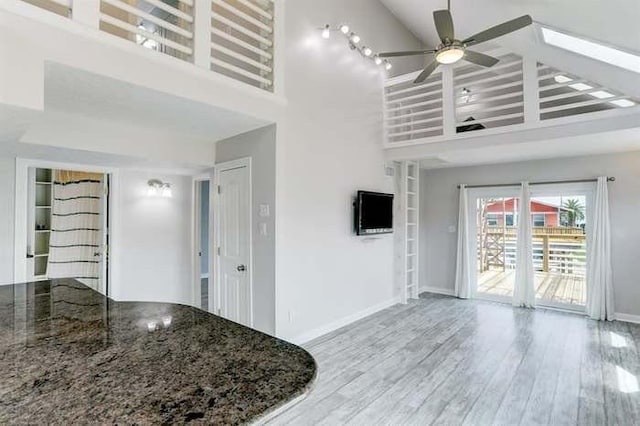 16525 Jamaica Cove Rd, Jamaica Beach, TX 77554 - unfurnished living room with baseboards, a high ceiling, wood finished floors, and a ceiling fan