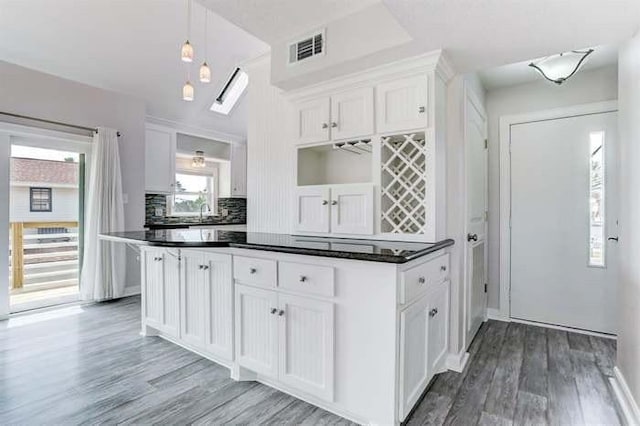 16525 Jamaica Cove Rd, Jamaica Beach, TX 77554 - kitchen featuring light wood-style flooring, white cabinets, visible vents, and dark countertops