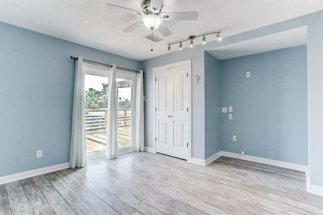 16525 Jamaica Cove Rd, Jamaica Beach, TX 77554 - interior space featuring baseboards, wood finished floors, track lighting, and a ceiling fan