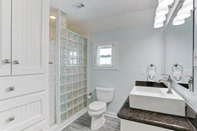 16525 Jamaica Cove Rd, Jamaica Beach, TX 77554 - full bath with visible vents, toilet, wood finished floors, vanity, and a walk in shower