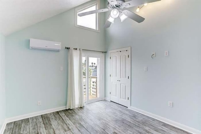 16525 Jamaica Cove Rd, Jamaica Beach, TX 77554 - unfurnished bedroom featuring baseboards, high vaulted ceiling, wood finished floors, and an AC wall unit