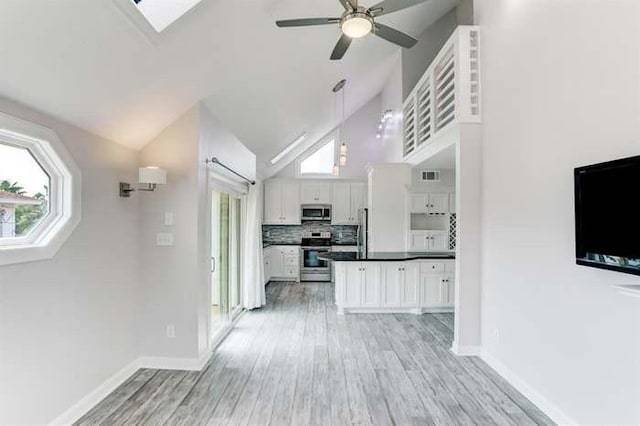 16525 Jamaica Cove Rd, Jamaica Beach, TX 77554 - kitchen featuring white cabinetry, stainless steel appliances, backsplash, dark countertops, and visible vents