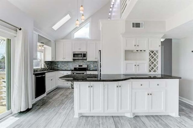16525 Jamaica Cove Rd, Jamaica Beach, TX 77554 - kitchen with white cabinetry, stainless steel appliances, a skylight, and visible vents