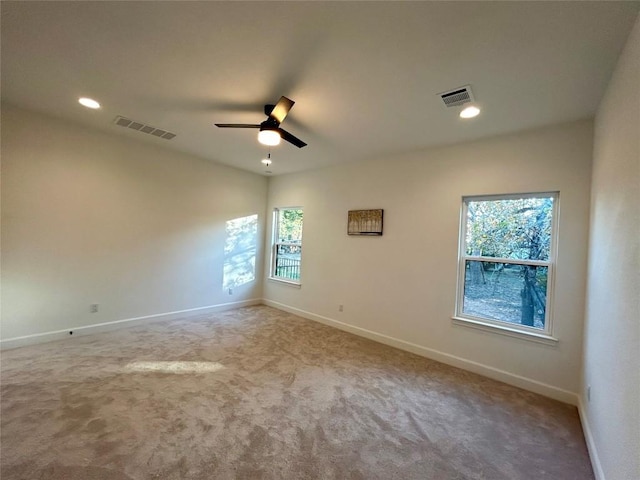 spare room with plenty of natural light, visible vents, and a ceiling fan