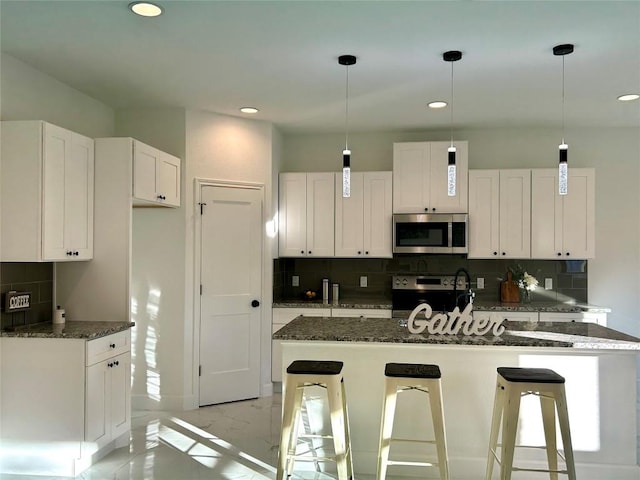 kitchen featuring decorative backsplash, marble finish floor, white cabinetry, and appliances with stainless steel finishes