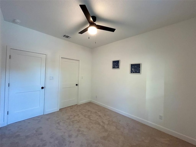 unfurnished bedroom featuring baseboards, visible vents, carpet, and a ceiling fan