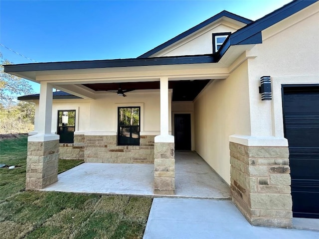 property entrance featuring stucco siding, stone siding, and a ceiling fan
