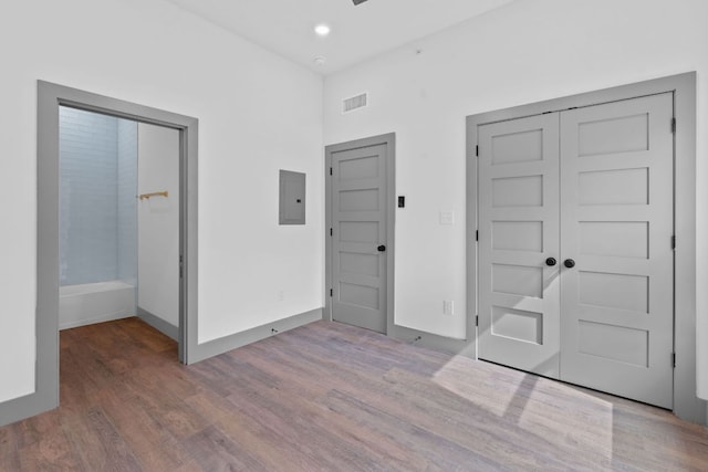 2450 Wickersham Ln Unit 2021, Austin, TX 78741 - unfurnished bedroom featuring wood finished floors, electric panel, a closet, recessed lighting, and baseboards