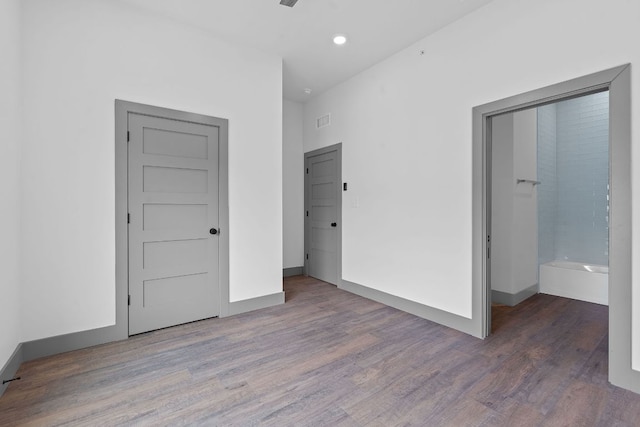 2450 Wickersham Ln Unit 2021, Austin, TX 78741 - unfurnished bedroom with wood finished floors, recessed lighting, and baseboards