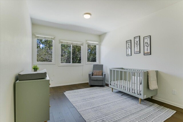 4500 Waterford Pl, Austin, TX 78731 - bedroom featuring multiple windows, dark wood-style flooring, and a nursery area