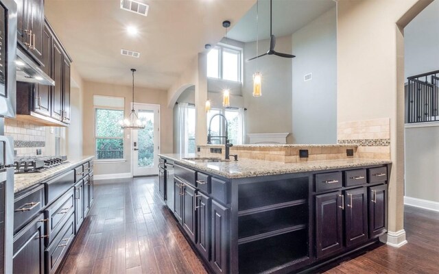 kitchen featuring dark wood-style flooring, a sink, stainless steel gas cooktop, and visible vents