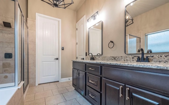 full bath with tile patterned flooring, double vanity, a sink, and a tile shower