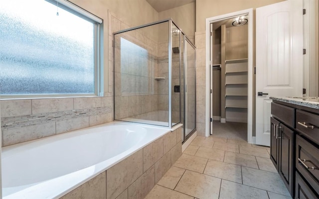 bathroom with a bath, vanity, a shower stall, and plenty of natural light