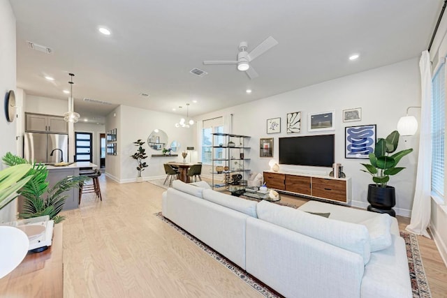 11808 Dillon Falls Dr, Austin, TX 78747 - living room with light wood-style flooring, recessed lighting, healthy amount of natural light, ceiling fan, and a chandelier