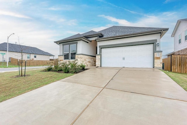 11808 Dillon Falls Dr, Austin, TX 78747 - prairie-style home with stone siding, concrete driveway, stucco siding, a garage, and roof with shingles