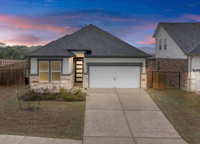 11808 Dillon Falls Dr, Austin, TX 78747 - view of front facade featuring a garage, concrete driveway, roof with shingles, stone siding, and stucco siding