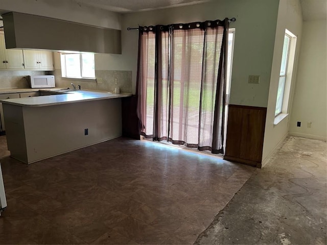 313 Golden Oaks Dr, Georgetown, TX 78628 - kitchen featuring white microwave, light countertops, a peninsula, and white cabinets