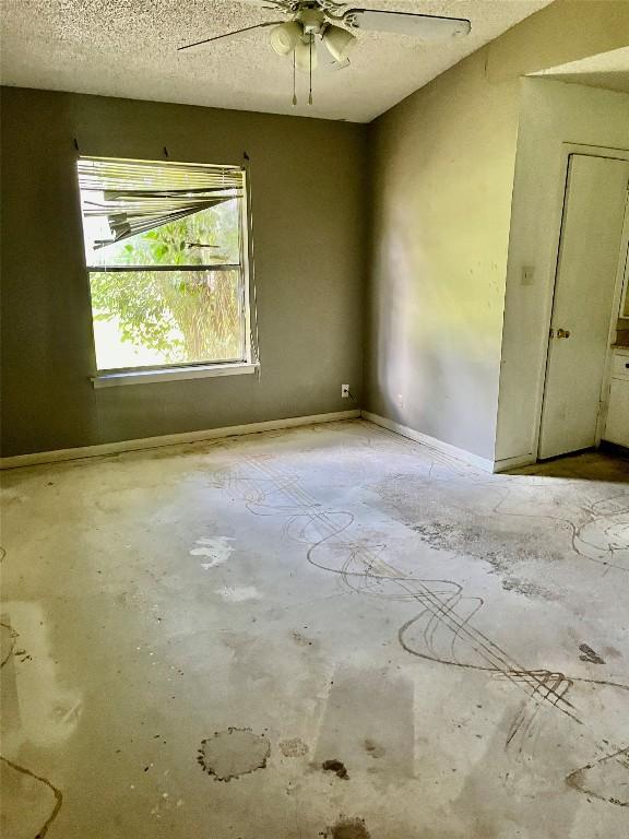 313 Golden Oaks Dr, Georgetown, TX 78628 - unfurnished room featuring unfinished concrete floors, a ceiling fan, and a textured ceiling