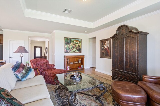 231 Tradinghouse Creek St, Georgetown, TX 78633 - living area featuring arched walkways, light wood-type flooring, a tray ceiling, and crown molding