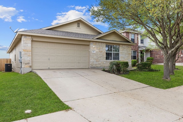 301 Drystone Trl, Liberty Hill, TX 78642 - view of front of home with stone siding, an attached garage, driveway, central AC unit, and a shingled roof