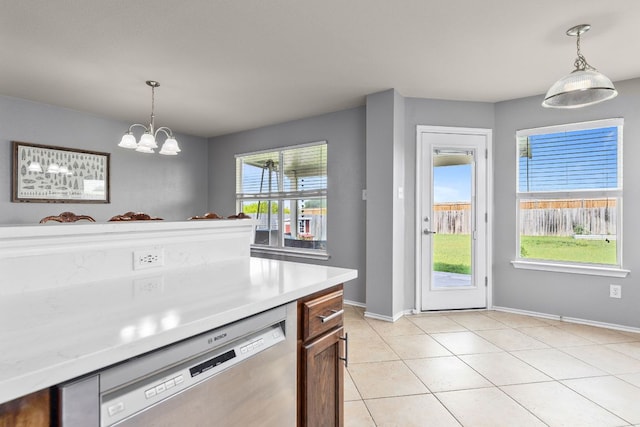 301 Drystone Trl, Liberty Hill, TX 78642 - kitchen featuring stainless steel dishwasher, baseboards, light countertops, light tile patterned flooring, and decorative light fixtures