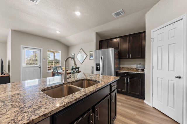 8517 Cantera Ridge Rd, Temple, TX 76502 - kitchen with stainless steel fridge with ice dispenser, a sink, vaulted ceiling, light stone counters, and light wood-type flooring