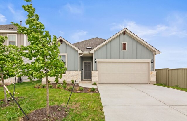 417 Singing Dove Way, Liberty Hill, TX 78642 - view of front of house with board and batten siding, an attached garage, concrete driveway, and stone siding