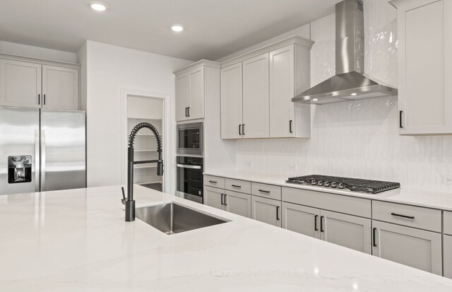417 Singing Dove Way, Liberty Hill, TX 78642 - kitchen featuring wall chimney exhaust hood, appliances with stainless steel finishes, tasteful backsplash, light stone countertops, and recessed lighting