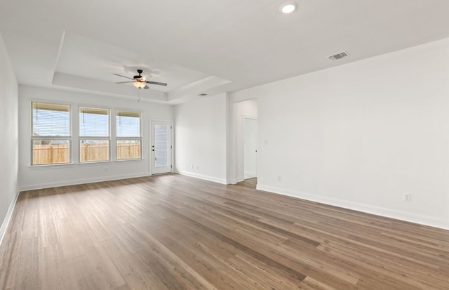417 Singing Dove Way, Liberty Hill, TX 78642 - unfurnished room with ceiling fan, a tray ceiling, wood finished floors, and recessed lighting