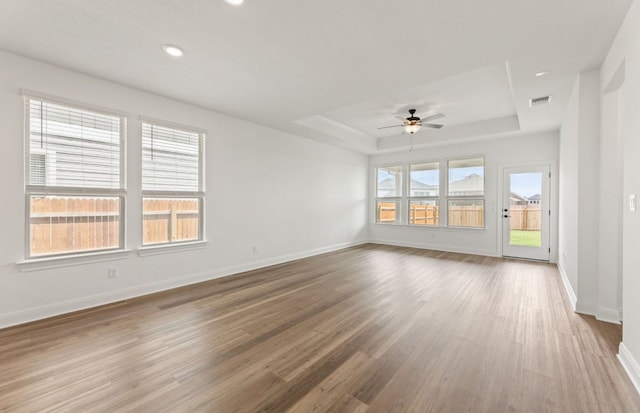 417 Singing Dove Way, Liberty Hill, TX 78642 - unfurnished room featuring a tray ceiling, wood finished floors, ceiling fan, and recessed lighting