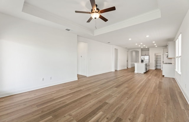 417 Singing Dove Way, Liberty Hill, TX 78642 - unfurnished living room with a raised ceiling, ceiling fan, recessed lighting, light wood finished floors, and ornamental molding
