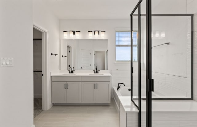 417 Singing Dove Way, Liberty Hill, TX 78642 - full bathroom with double vanity, a stall shower, a walk in closet, a bath, and tile patterned flooring