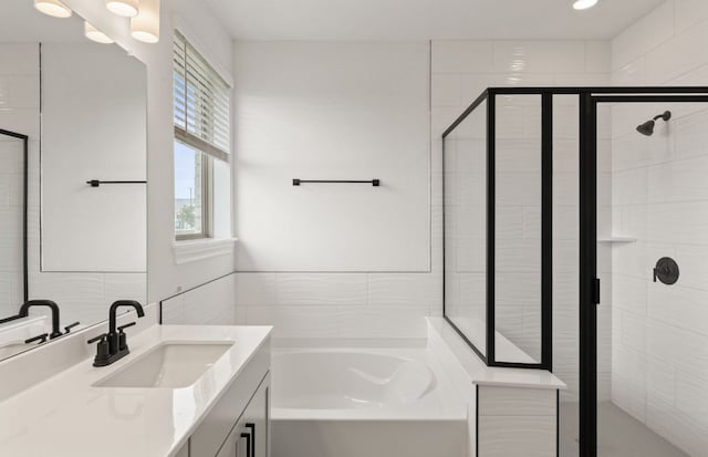 417 Singing Dove Way, Liberty Hill, TX 78642 - full bathroom with vanity, a bath, a stall shower, and tile walls