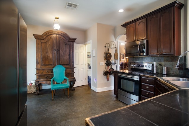 15405 Sutton Dr, Austin, TX 78734 - kitchen featuring stainless steel appliances, concrete floors, tasteful backsplash, dark countertops, and dark brown cabinets