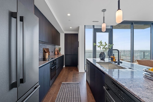 84 E Ave Unit 1904, Austin, TX 78701 - kitchen featuring black appliances, a sink, modern cabinets, dark wood finished floors, and light stone countertops