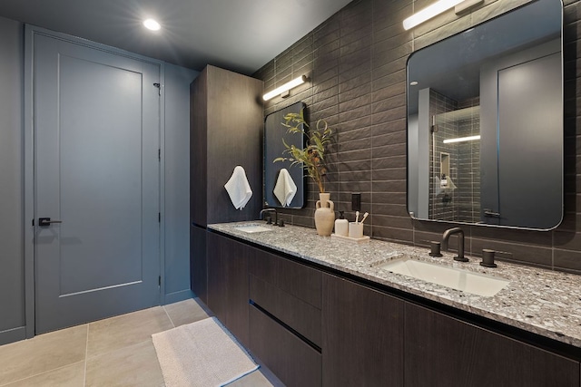 84 E Ave Unit 1904, Austin, TX 78701 - full bathroom with double vanity, tile patterned floors, a tile shower, and tile walls