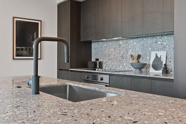 84 E Ave Unit 1904, Austin, TX 78701 - kitchen featuring gray cabinets, a sink, decorative backsplash, and modern cabinets