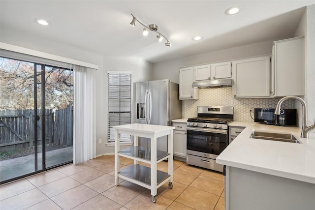 11404 Walnut Ridge Dr Unit 5, Austin, TX 78753 - kitchen featuring gas stove, under cabinet range hood, a sink, light countertops, and tasteful backsplash
